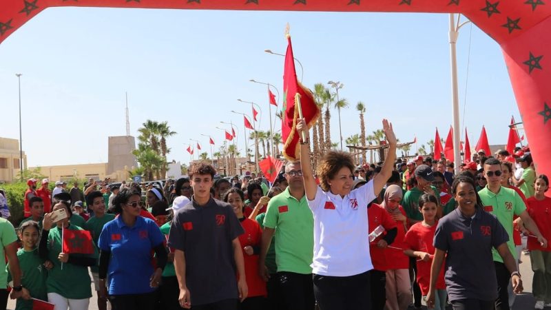 سباق التناوب الرمزي المسيرة الخضراء : البطلة نزهة بدوان تحمل العلم الوطني في المرحلة 14 ( بوجدور- الكركرات).